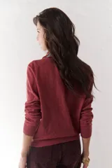 Sweater color burdeos confeccionado en un tejido suave, con cuello redondo y bordado distintivo.