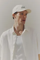Camisa de manga corta color crema, de corte holgado, con cuello inglés, tapeta lisa, canesú en la espalda y bajo recto. Confeccionada en mezcla liviana de lino y viscosa.