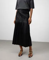 Falda midi negra de efecto piel, con textura arrugada en la parte superior y pliegues amplios en el resto de la falda.
