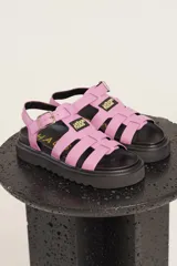 Sandalias de cuero sintético color lila con plataforma negra y tiras anchas cruzadas.