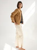 Chaqueta color marrón claro de lino y algodón, con cuello mao, cierre frontal con botones de madera y bolsillos laterales.