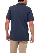 Remera tipo polo color verde agua, de corte clásico, con cuello abotonado y mangas cortas con ribete azul.