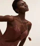 Conjunto de collar y caravanas con baño de oro light. El collar es de eslabones finos con colgante de pétalos de resina. Las caravanas son modelo botón.