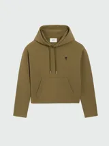 Buzo con capucha color verde oliva, con cordones ajustables y bolsillo tipo canguro. Logo bordado de corazón negro en el pecho. Corte holgado.