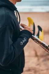 Buzo canguro negro con capucha y estampado en la espalda con la frase "Glassy Waves".