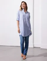 Camisola larga de algodón color blanco, marca Dash. Tiene cuello con solapa, abertura central con botones, bolsillo aplicado en el pecho, mangas regulables con presilla y botón, y bolsillos laterales en la costura.