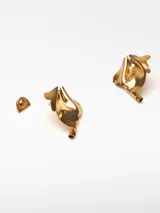 Par de aros metálicos dorados con forma irregular y relieve. Cierre con broche a presión.