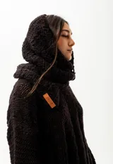 Cuello con capucha tejido a mano en lana merino negra, con detalle de hebilla de cuero en el lateral.
