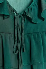 Camisa negra de manga larga abullonada con escote en pico y volantes.