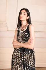 Vestido midi plisado con estampado de hojas en tonos marrones y ribete blanco en cuello y sisas.