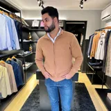 Campera tejida gris con cierre frontal, cuello alto y bolsillos laterales.