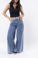 Pantalón de jean de tiro alto, corte wide leg, con paneles de denim en tonos contrastantes y costuras marcadas en el frente.