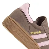 Zapatilla Adidas Handball Spezial, color marrón topo, con tres franjas laterales en rosa pálido y detalles en dorado. Presenta un cuello acolchado en rosa pálido y suela de goma color caramelo.