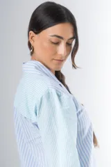 Pijama de algodón a rayas verticales celestes y blancas, compuesto por una camisa de manga larga con botones y un short con elástico en la cintura.