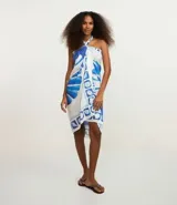 Canga rectangular de viscosa certificada, con estampado en tonos blanco y azul que incluye motivos de caracolas y patrones geométricos en el borde.