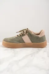 Zapatilla deportiva de cuero color verde oliva con detalles en rosa y suela marrón.