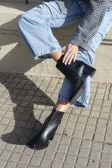 Bota corta color marrón de gamuza, con punta cuadrada, cierre lateral y taco de madera.