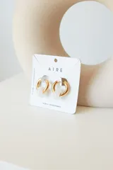 Aros de acero quirúrgico hipoalergénico con piedras naturales azules. Diseño de aro con dije circular colgante.