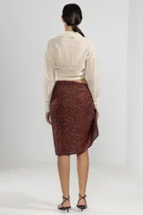 Camisa color crema de manga larga con lazo en la cintura y botones nacarados.