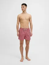 Short de baño rojo y blanco a rayas verticales con pequeños dibujos de veleros negros. Tiene cintura elástica con cordón ajustable.