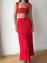 Falda larga tejida color vino tinto con brillo dorado, de corte ajustado y abertura lateral en la pierna.