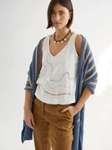 Chal tejido a crochet con diseño a rayas horizontales en tonos azul y beige. Tiene volados sutiles en los bordes.