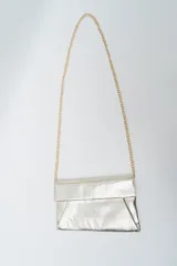 Cartera tipo sobre o clutch de material sintético con acabado metálico color bronce/dorado. Posee una correa de cadena fina dorada para llevar al hombro o cruzada.