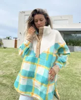 Buzo largo con cuello alto de polar color crema y cuerpo con estampado de cuadros en tonos celeste, amarillo y blanco.