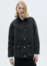 Chaqueta oversize de algodón negro con cuello camisero de pana, cierre frontal con cremallera y botones a presión, bolsillos de parche con solapa y bolsillos de ribete.