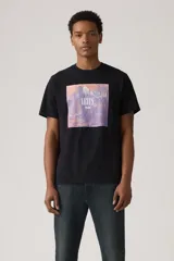 Remera negra de corte clásico con estampa rectangular en el frente que representa un paisaje montañoso en tonos naranja y violeta, con el logo de Levi's superpuesto.