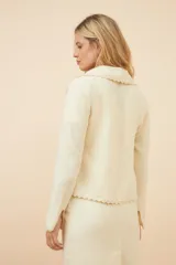 Chaqueta color crudo de lana fina sin teñir, de corte recto con cuello solapa y mangas 3/4.