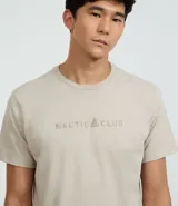 Remera de algodón color beige claro, manga corta y cuello redondo, con estampa localizada en el pecho con el texto "NAUTIC CLUB" y un logo de vela.
