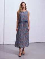 Vestido largo sin mangas de gasa estampada en tonos azules y marrones. Presenta escote redondo y corte en la cintura con punto smock.