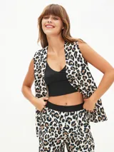 Chaleco sastre negro, sin mangas, con escote en V profundo y cierre frontal de botones. Presenta un bolsillo superior simulado en el lado izquierdo.