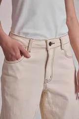 Pantalón de jean color crudo, corte palazzo con godets y costuras a contratono.