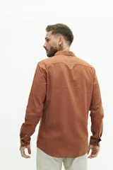 Camisa de lino color beige, de manga larga, corte semi slim y logo bordado en el pecho.