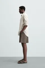 Bermuda negra de lino con calce relajado. Presenta cintura elástica ajustable con cordón, bolsillos frontales y un bolsillo trasero de plastrón.