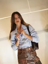 Camisa celeste a rayas verticales con bordados de un sol y un caballo en la espalda.
