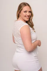 Pijama de modal blanco, compuesto por remera sin mangas con detalle de puntilla en el escote y lazo en el centro, y short con cintura elástica.