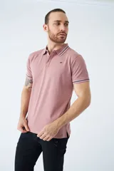 Remera cuello polo blanca de piqué, corte regular, manga corta, logo estampado y terminaciones a contratono en cuello y mangas con rayas rojas, grises y azules.