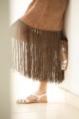 Vestido corto dorado de lurex metalizado, con flecos largos en el ruedo.