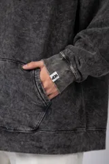 Buzo canguro color ocre con capucha y cordones negros, de corte oversize y confeccionado en tela de algodón friza con teñido artesanal y estampa circular en el pecho.