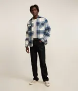 Campera trucker masculina de terciopelo a cuadros en tonos azul, blanco y beige. Tiene cuello inglés, cierre abotonado, bolsillos delanteros y laterales.