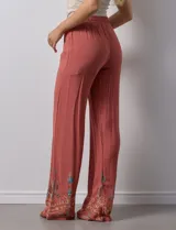 Pantalón verde oliva de rayón con cintura elastizada tipo smock y bordados florales en los bajos.
