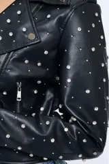 Campera negra estilo motoquera de cuero sintético con tachas plateadas.