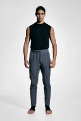 Pantalón de jogging deportivo gris oscuro, de corte ajustado, con cintura elástica ajustable con cordón, bolsillos laterales y bolsillos con cierre en las piernas.
