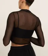 Blusa deportiva de tule negro, con cuello alto, mangas largas y estampa frontal con la palabra 'muse'.