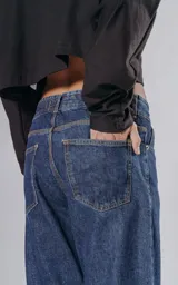 Pantalón de denim azul con cinco bolsillos y corte wide leg.