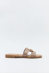 Sandalias planas color beige con dos tiras anchas en la capellada y hebilla metálica dorada.