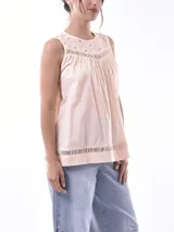 Blusa color durazno sin mangas, con cuello redondo y detalle de calado en la parte superior y en el ruedo.